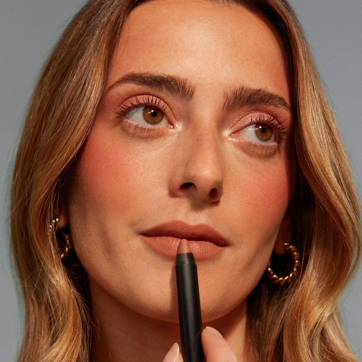 Taylor Frankel applying on Intense Matte Lip + Cheek pencil