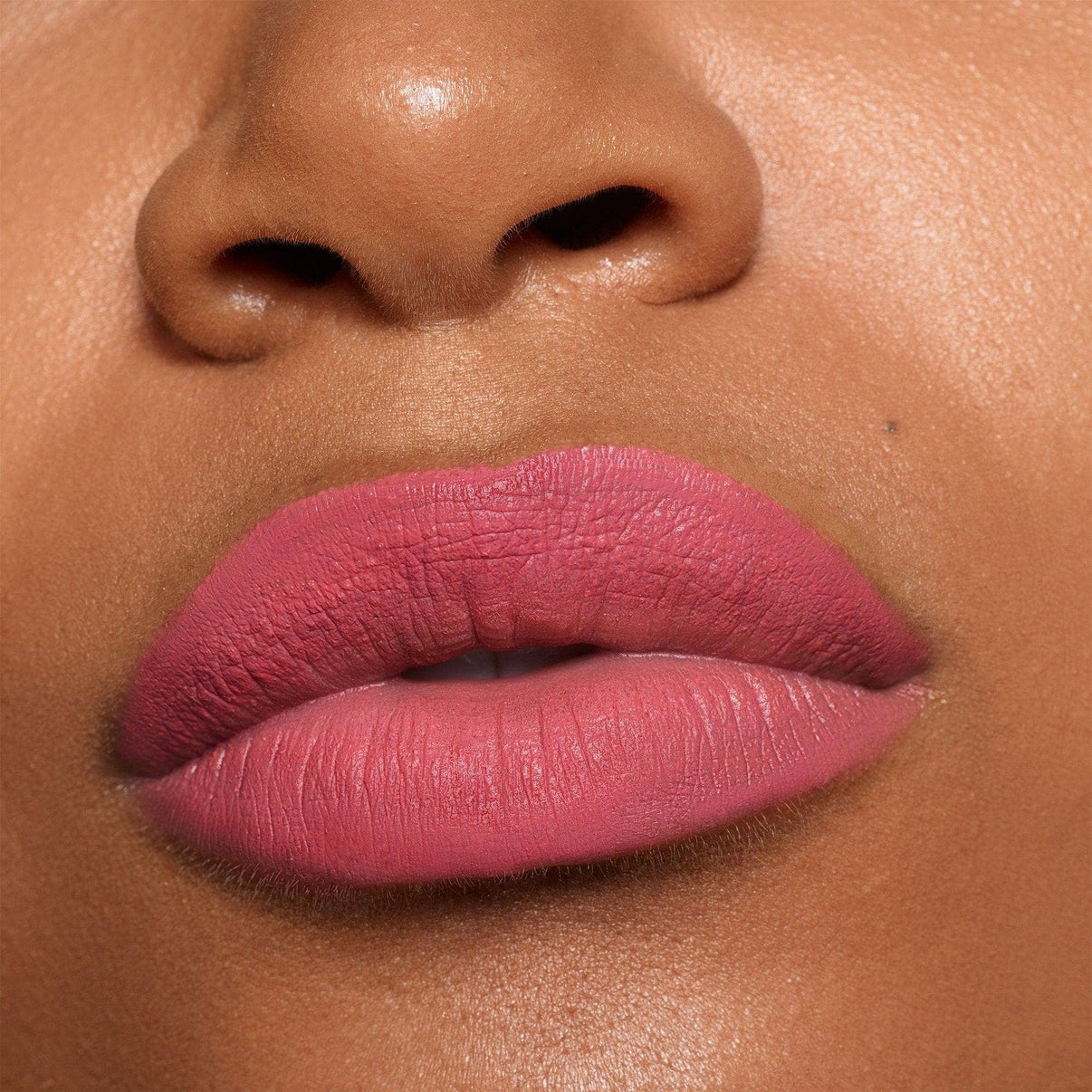 Dark skinned lips wearing Intense Matte Lip + Cheek pencil in shade kiss