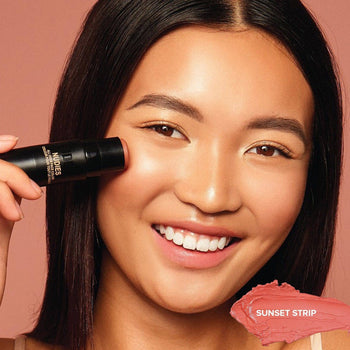 Asian girl applying on Nudies Blush Stick in shade Sunset Strip